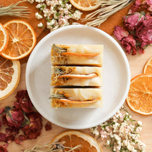 Charger l'image dans la galerie, Savon artisanal naturel pin et pamplemousse, fait d'huiles essentielles, coloré orange et beige, décoré d'orange et de fleurs