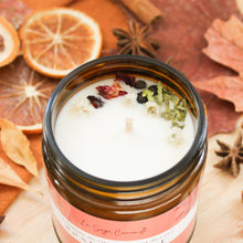 Charger l'image dans la galerie, Chandelle naturelle rose et cèdre, décoré de pétales de rose et feuilles de cèdre, parfumé d'huiles essentielles, contenant de verre ambré, vue de côté