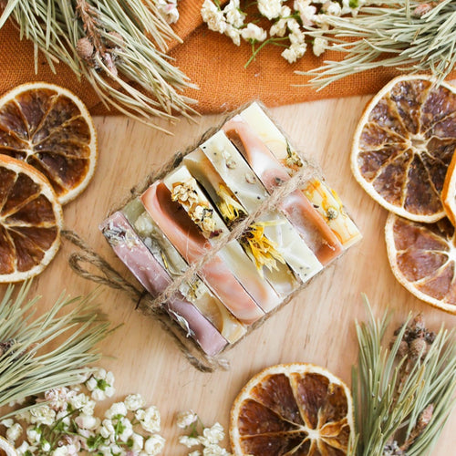 Ensemble dde huit échantillons de savons artisanaux naturels, colorés naturellement avec plantes et argiles, décoré d'orange et de pin, attachés ensemble avec cordelette