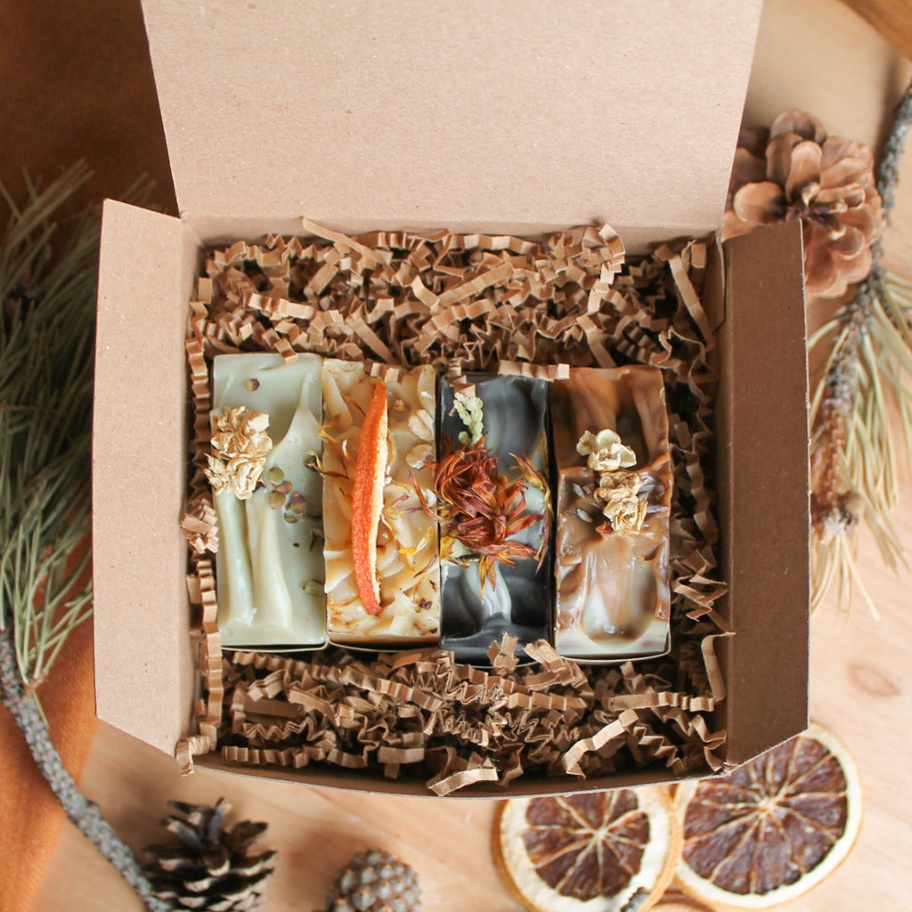 Boîte cadeau de 4 savons artisanaux naturels, décoré de pin et oranges, dans boîte en carton