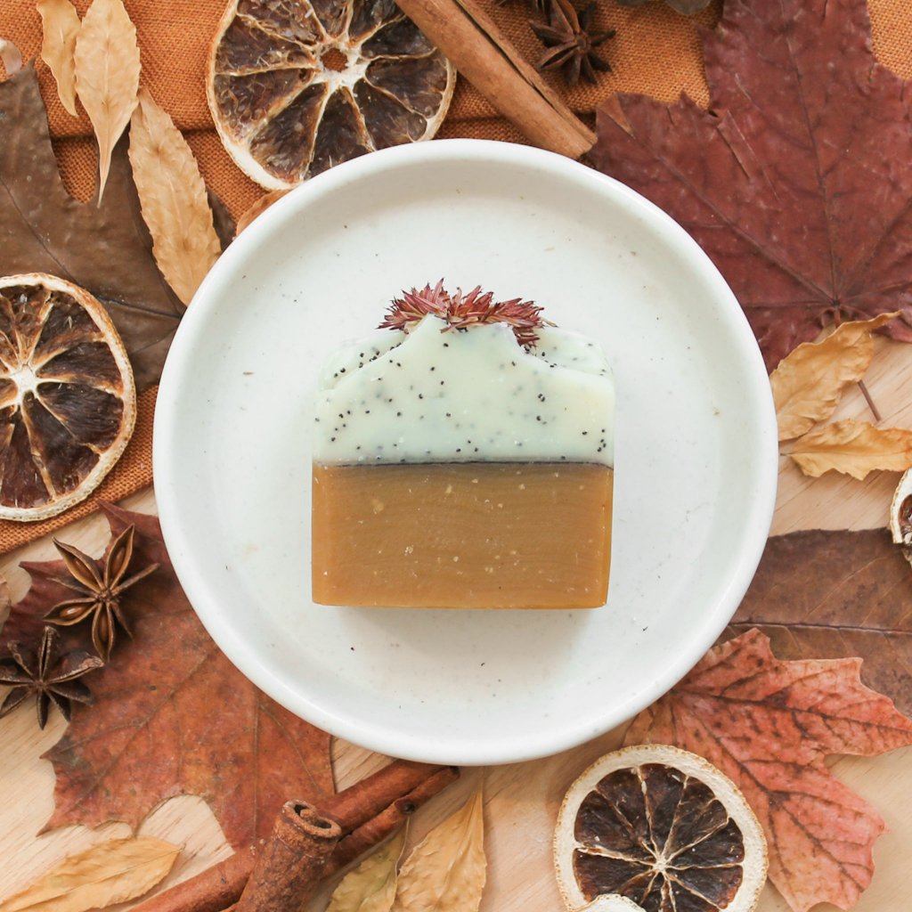 Savon artisanal naturel en barre pour le corps Calendule, miel et pavot, sans odeur, coloré orange et blanc, avec graines de pavot, décoré de fleurs