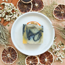 Load the image into the gallery, Savon artisanal naturel Romarin, tangerine et patchouli, Coloré naturellement noir charbon, vert et orange, Avec grains de pavot comme exfoliant, Décoré de tranche d&#39;orange et feuilles
