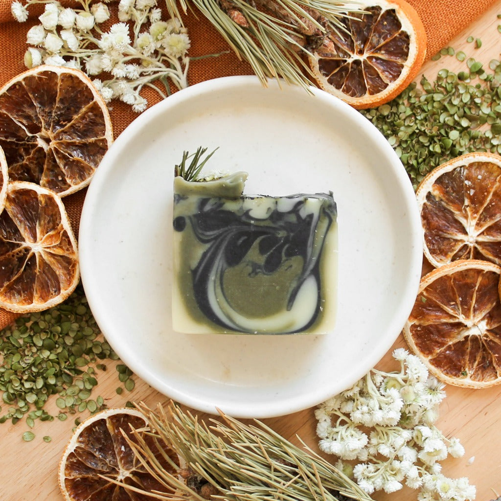 Savon naturel sapin et cèdre, coloré de tourbillons verts et noirs charbon, décoré de cèdre et de fleurs