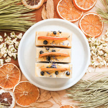 Charger l'image dans la galerie, Savon pour le corps orange et genévrier, fait d'ingrédients naturels et huiles essentielles, coloré naturellement avec argile et plantes, décoré de fleurs et feuilles
